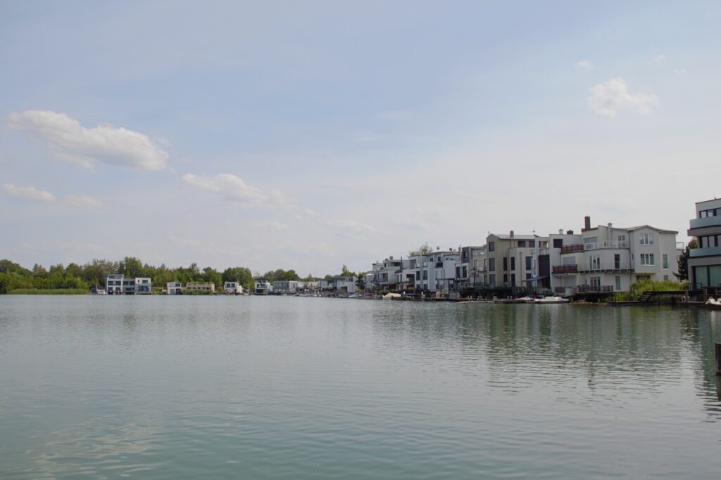 Blick über das Wasser auf moderne Uferhäuser am Hainer See in Kahnsdorf